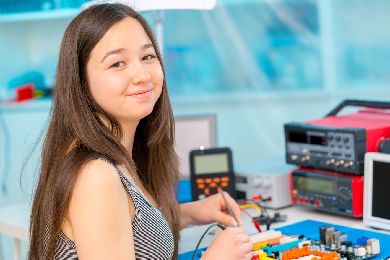 Girl schoolgirl in the classroom in the laboratory of robotics and electronics